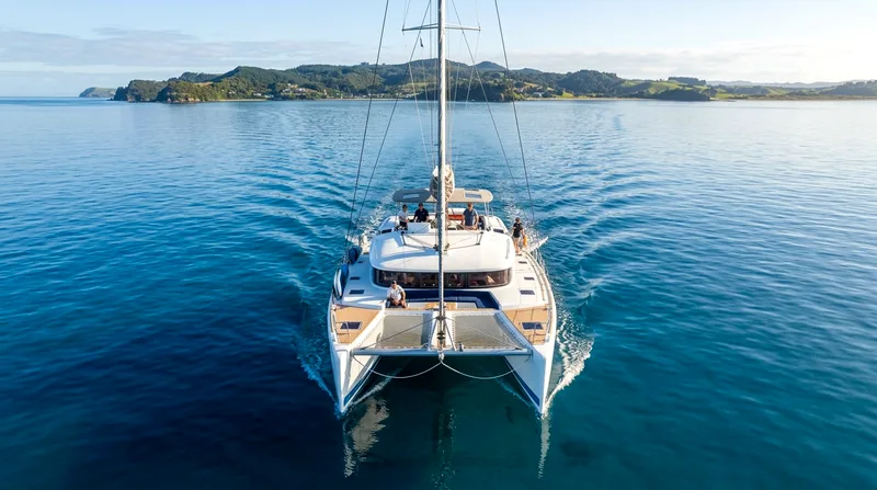 Catamaran's twin hulls cutting through calm water showing stability and minimal heel