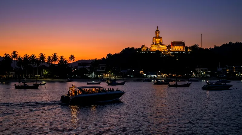 Speedboat approaching Bangrak Beach at dusk with Big Buddha Temple visible on hillside